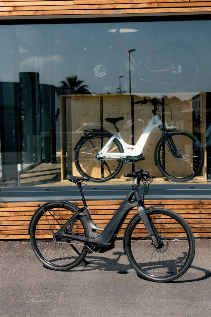 Trois vélos électriques de la marque ultima mobility rangés dans un magasin spécialisé